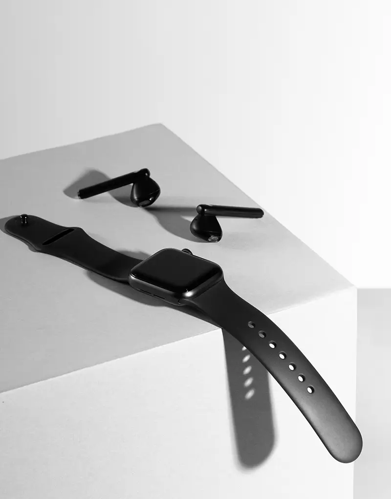 Retouched image of a watch and earbuds, enhanced by professional photo retouching services from Tech Cloud Ltd